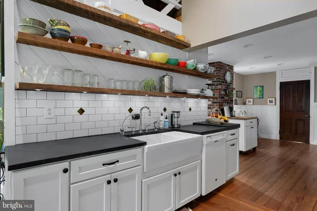 a bedroom with a large bed and wooden floor