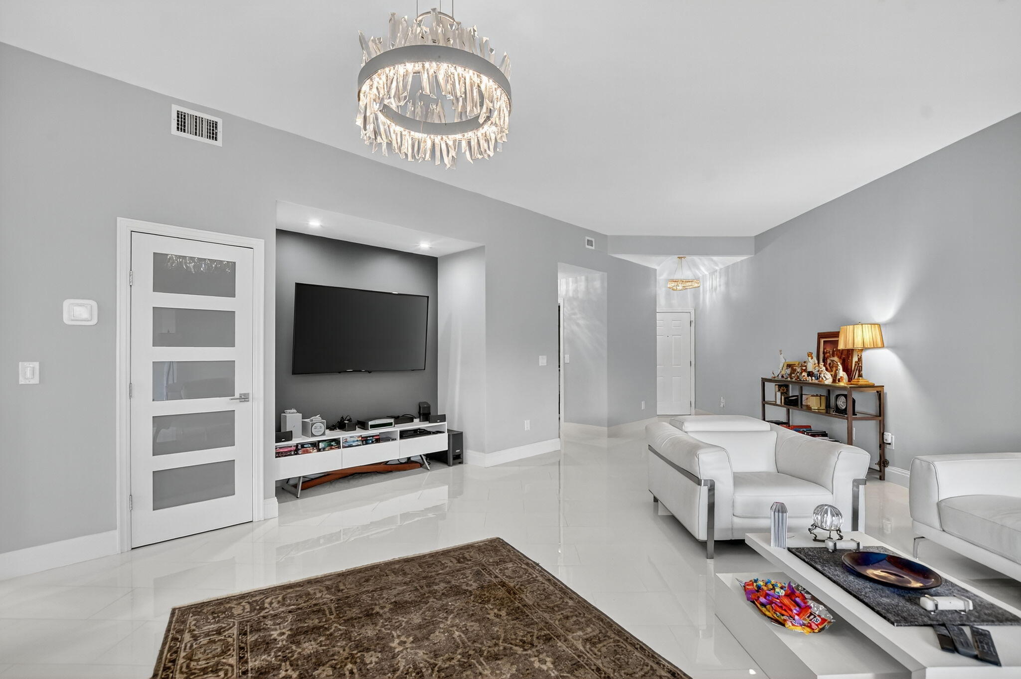 7535 La Paz Boulevard, Unit 105 Boca Raton, FL 33433 - Photo 8 of 54 a living room with furniture and a flat screen tv