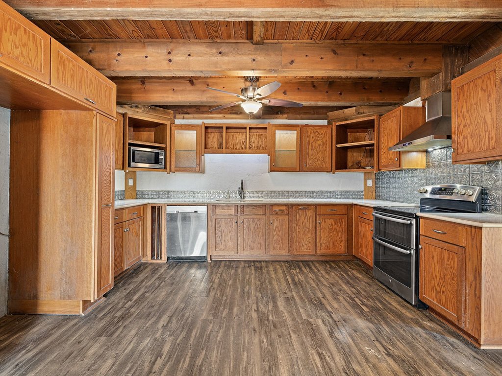 Rich wood ceilings and matching cabinetry define this character-filled kitchen space.