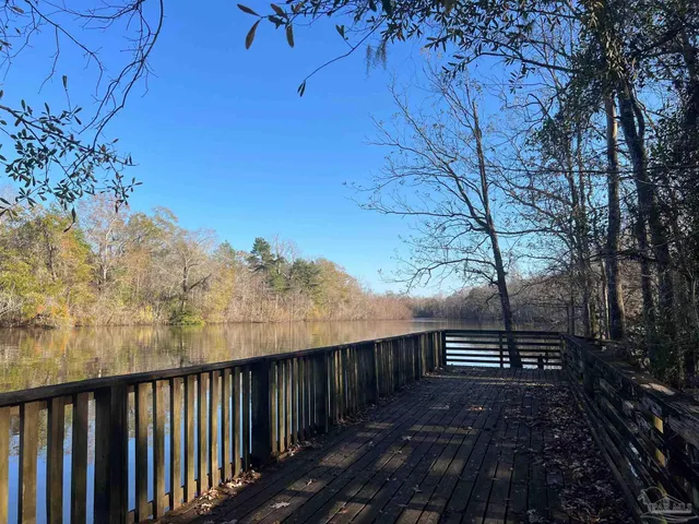a balcony with wooden floor and trees
