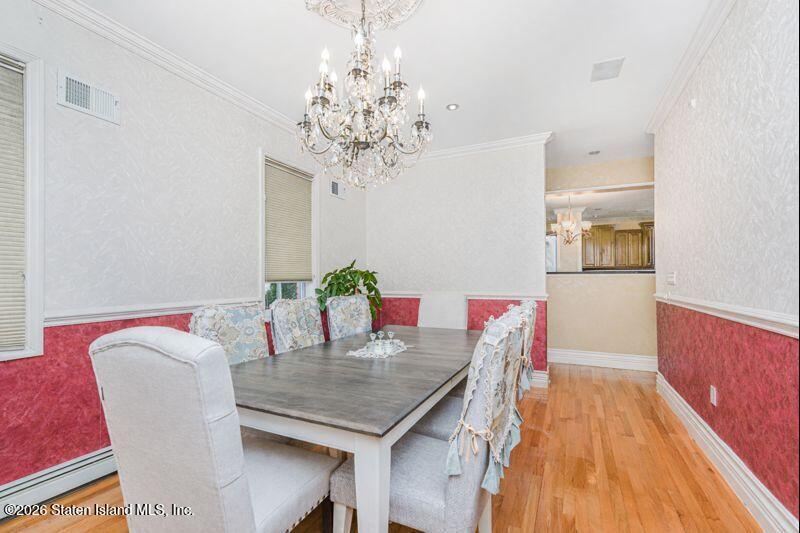 5125 Amboy Road Staten Island, NY 10312 - Photo 15 of 33 a dining room with furniture a chandelier and wooden floor