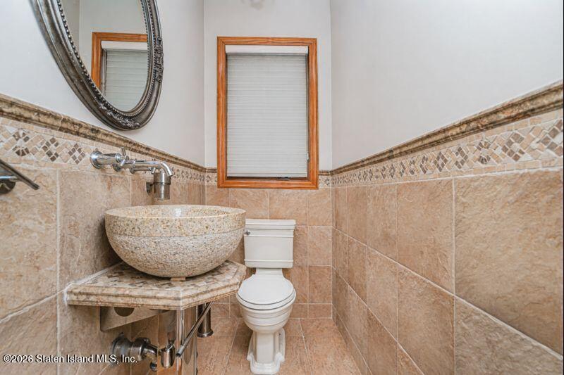 5125 Amboy Road Staten Island, NY 10312 - Photo 23 of 33 a bathroom with a toilet a sink and a mirror