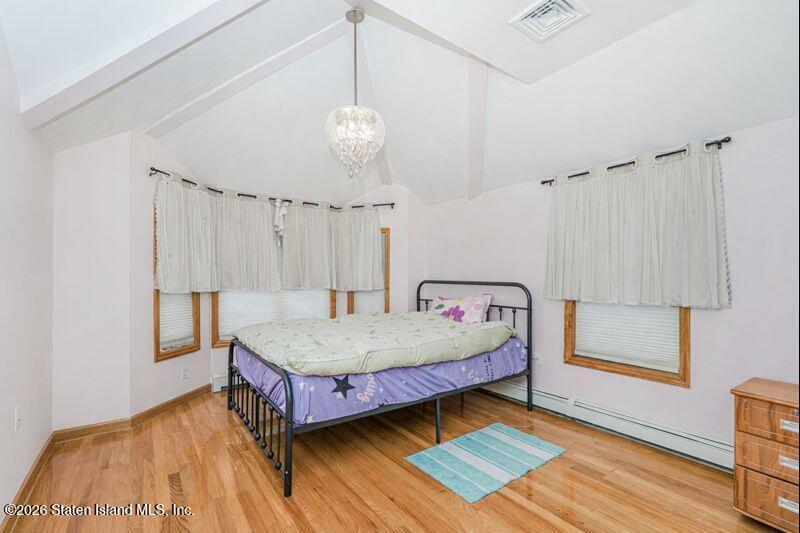 5125 Amboy Road Staten Island, NY 10312 - Photo 32 of 33 a spacious bedroom with a bed chandelier and a window