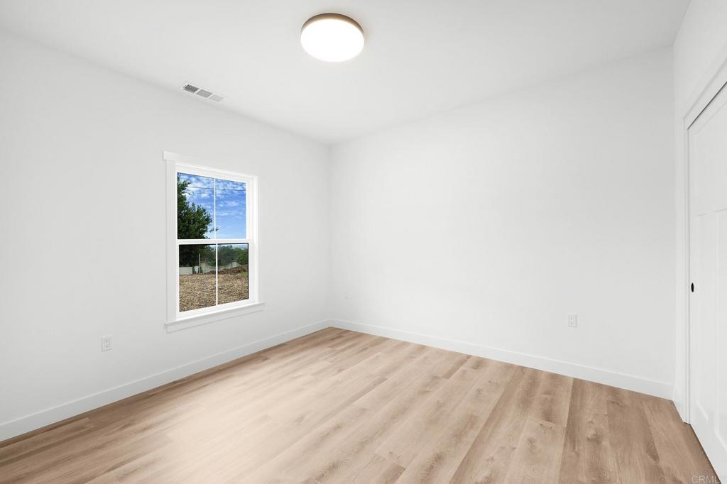 1547 Dickey Street Fallbrook, CA 92028 - Photo 33 of 45 an empty room with wooden floor and windows