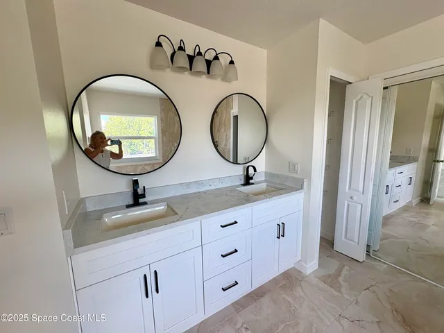 a bathroom with a double vanity sink and a mirror