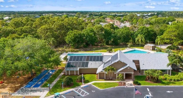 an aerial view of a house with swimming pool and garden