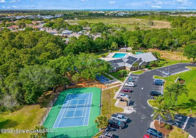 an aerial view of residential houses with outdoor space and trees