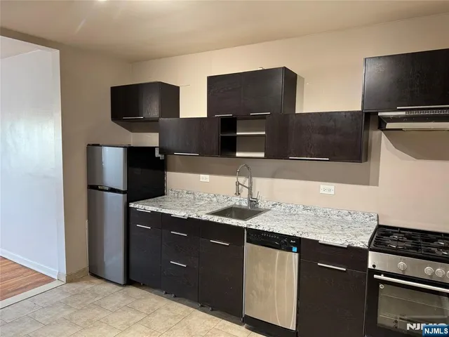 a kitchen with stainless steel appliances granite countertop a sink and a microwave