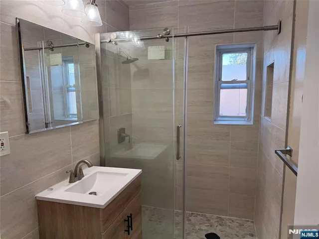a bathroom with a sink a shower and a mirror