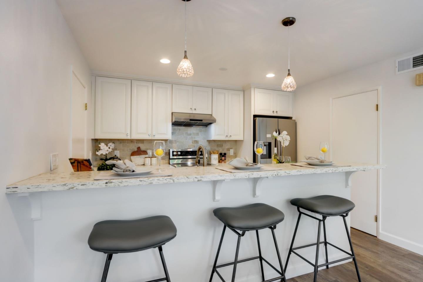 1653 Albatross Drive Sunnyvale, CA 94087 - Photo 13 of 44 a kitchen with stainless steel appliances granite countertop a sink a stove a refrigerator cabinets and chairs with wooden floor