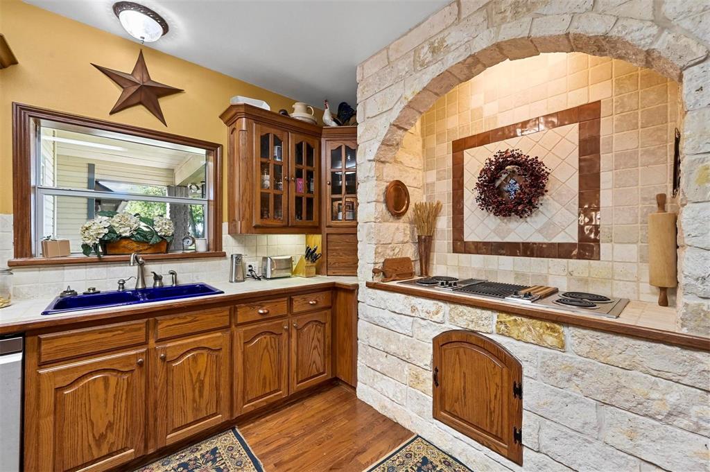 1990 Ripy Road Krum, TX 76249 - Photo 15 of 40 a kitchen with stainless steel appliances granite countertop a sink and cabinets with wooden floor