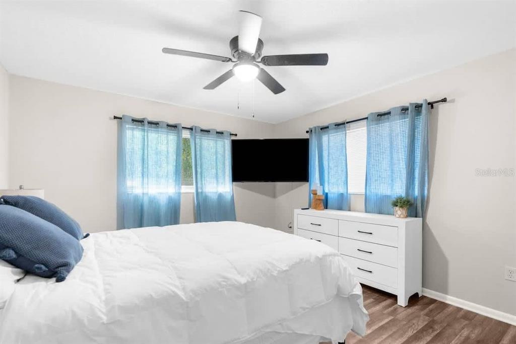 13501 Whitby Road Hudson, FL 34667 - Photo 18 of 25 a large bedroom with a bed and a flat tv screen on dresser