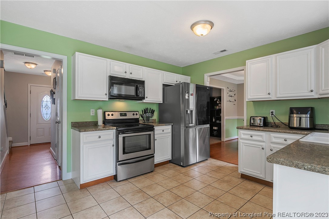 250 Pender Road Spring Lake, NC 28390 - Photo 16 of 50 a kitchen with granite countertop a refrigerator and a stove top oven