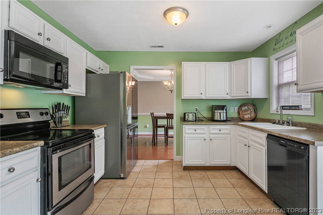 250 Pender Road Spring Lake, NC 28390 - Photo 17 of 50 a kitchen with stainless steel appliances granite countertop a stove a sink and a microwave