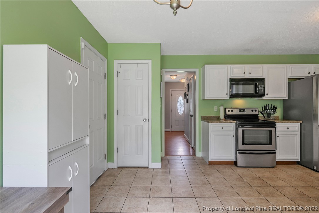 250 Pender Road Spring Lake, NC 28390 - Photo 21 of 50 a kitchen with granite countertop a refrigerator and a stove top oven
