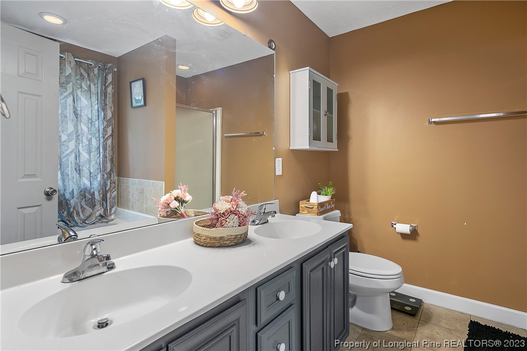 250 Pender Road Spring Lake, NC 28390 - Photo 28 of 50 a bathroom with a sink a toilet and shower curtain