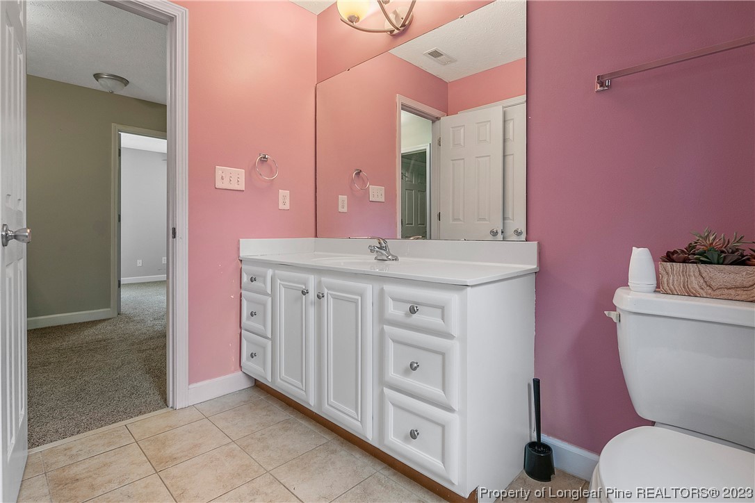 250 Pender Road Spring Lake, NC 28390 - Photo 37 of 50 a bathroom with a granite countertop toilet a sink and a mirror