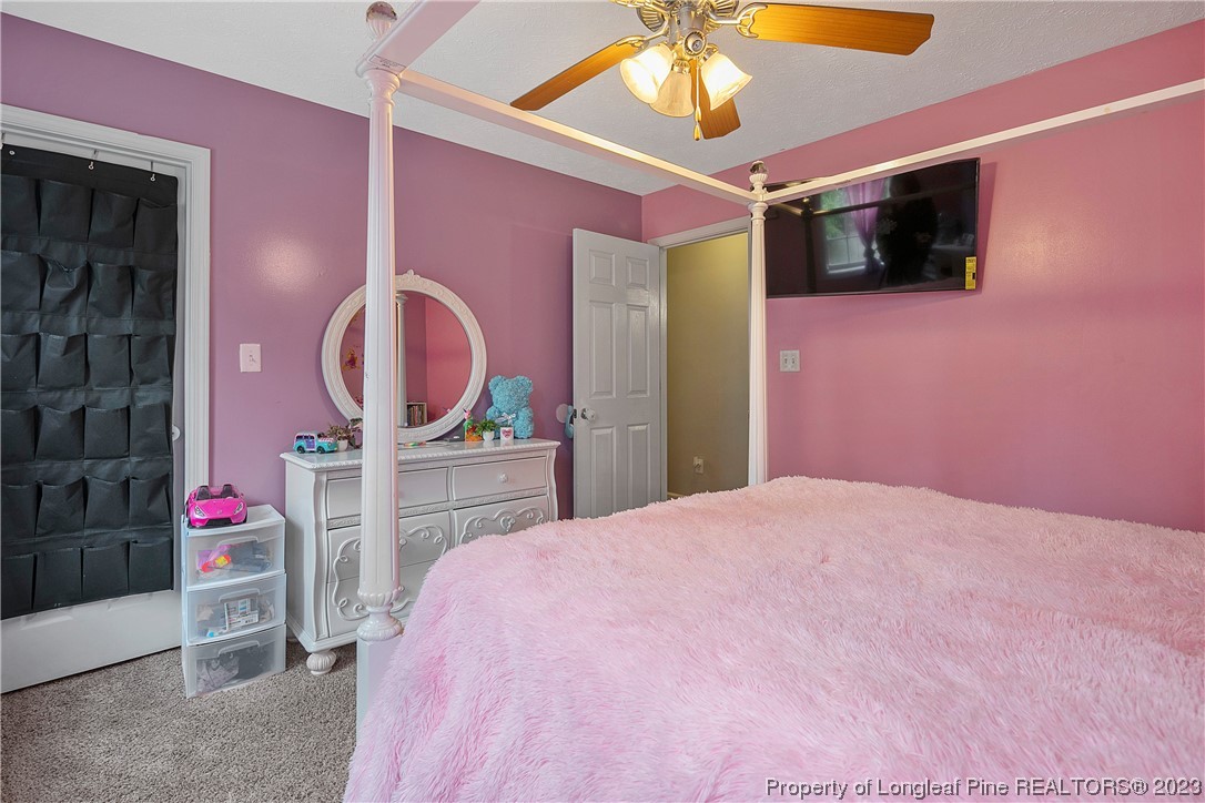 250 Pender Road Spring Lake, NC 28390 - Photo 45 of 50 a bedroom with a bed dresser and a chandelier
