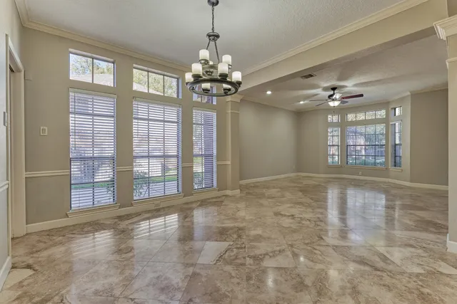 a view of an empty room with a window and a kitchen