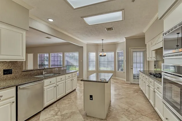 a kitchen with granite countertop a sink and a refrigerator