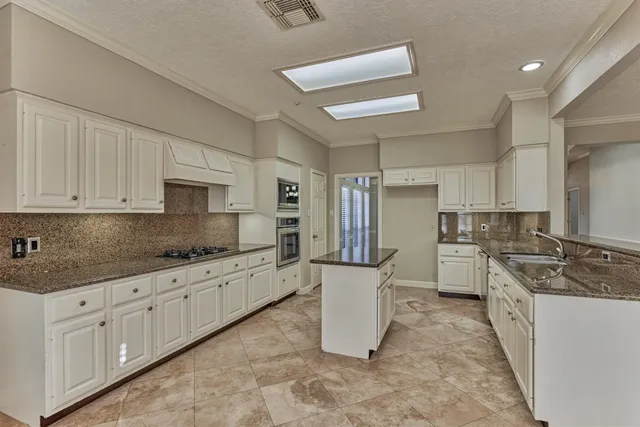 a kitchen with sink stove and cabinets