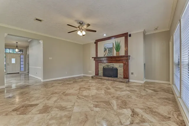 a view of an empty room with a fireplace and a window