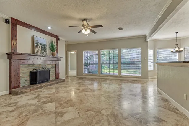 a view of an empty room with a fireplace and a large window