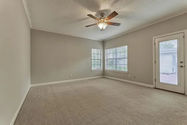 an empty room with fan and windows