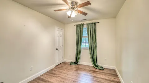 an empty room with closet and a chandelier fan