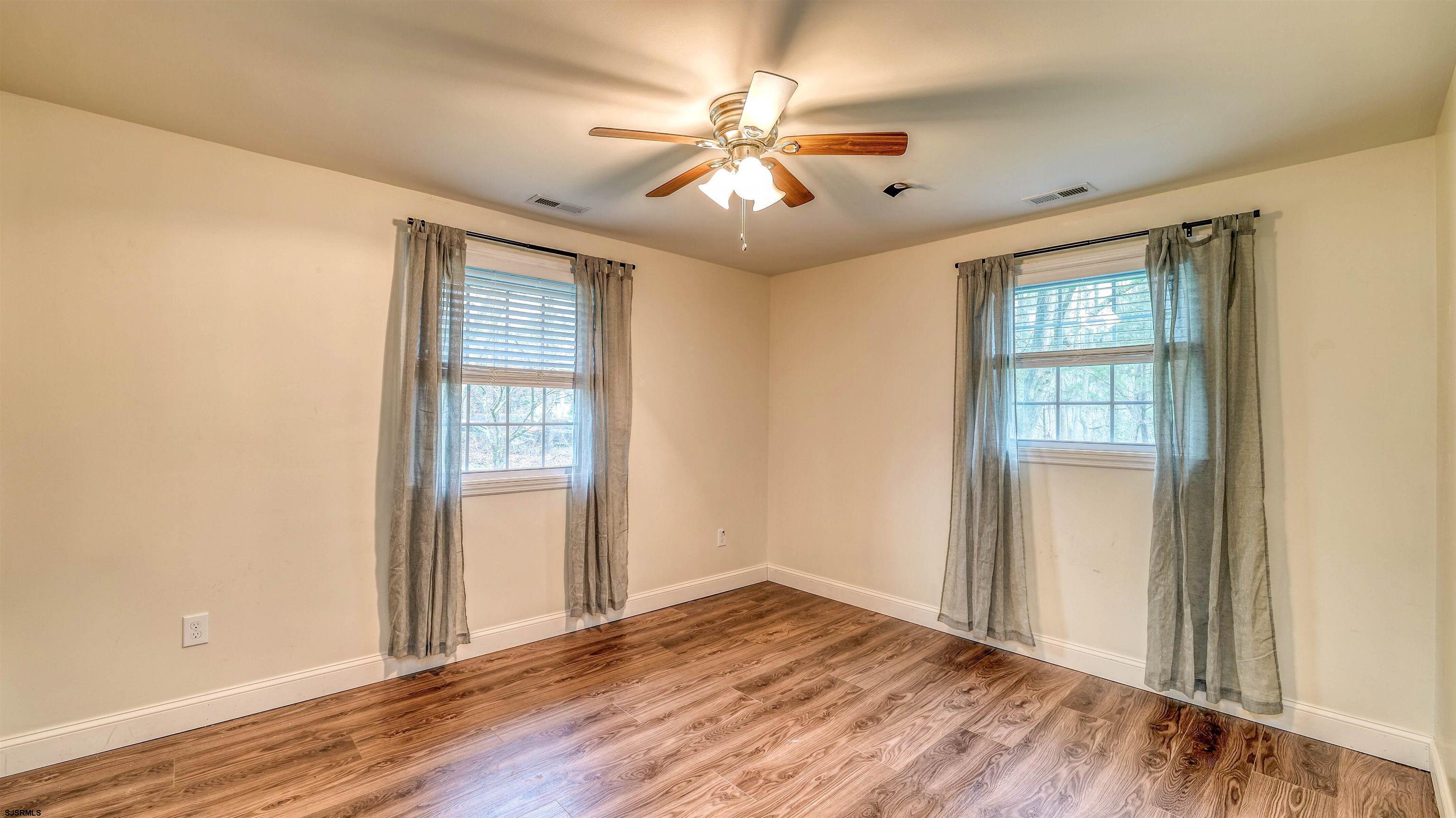 1048 Ocean Heights Avenue Egg Harbor Township, NJ 08234 - Photo 19 of 30 a view of an empty room with wooden floor and a window