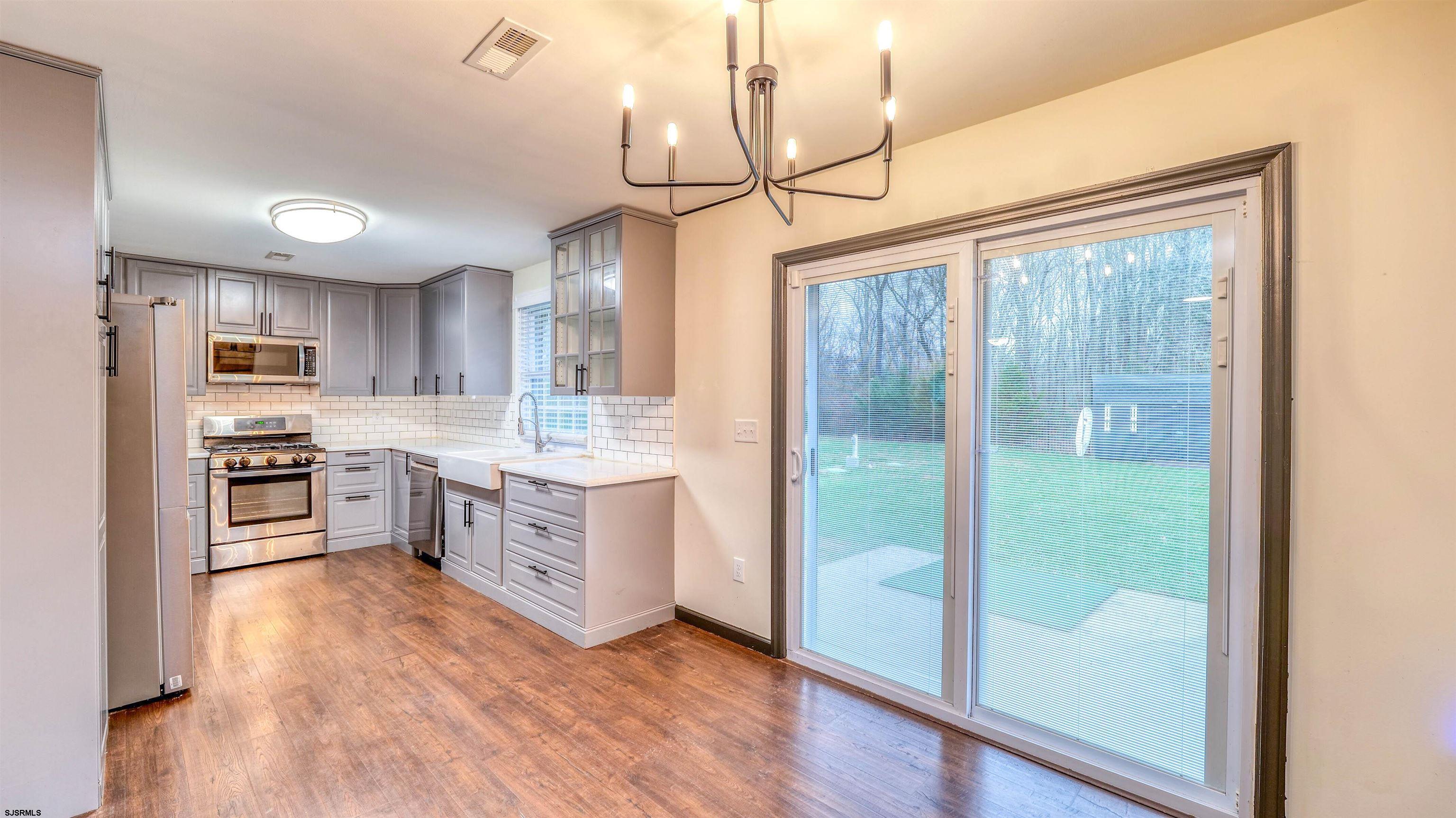 1048 Ocean Heights Avenue Egg Harbor Township, NJ 08234 - Photo 9 of 30 a kitchen with stainless steel appliances granite countertop a refrigerator a sink dishwasher a stove and white cabinets with wooden floor