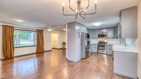 a view of kitchen with stainless steel appliances granite countertop cabinets and wooden floor
