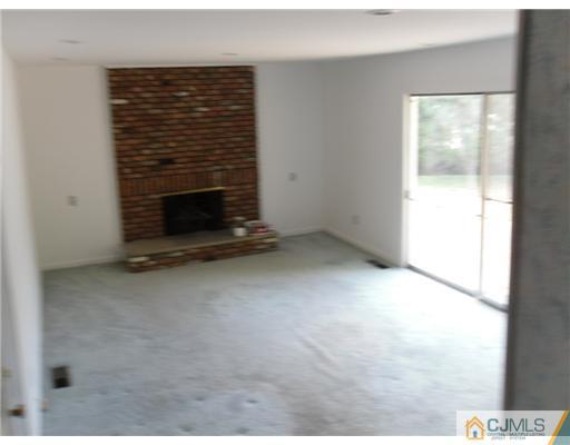 9 Bodnarik Road Edison, NJ 08837 - Photo 8 of 8 a view of an empty room with a fireplace and a window