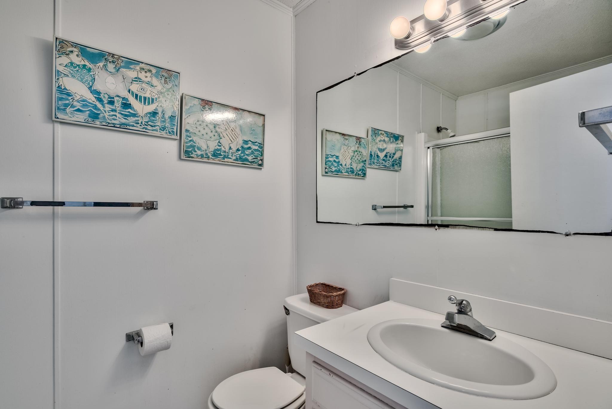 5357 West County Highway 30A Santa Rosa Beach, FL 32459 - Photo 19 of 22 a bathroom with a toilet a sink and mirror