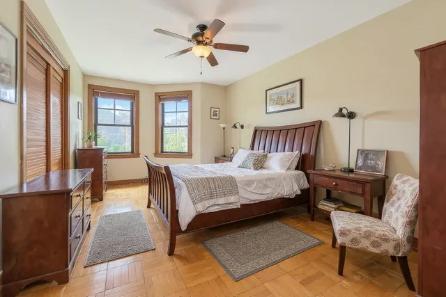 a bedroom with a bed a chair and a chandelier