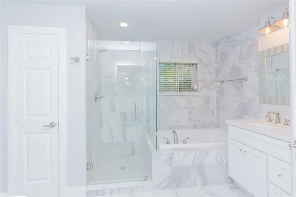 a bathroom with a bathtub shower sink and vanity