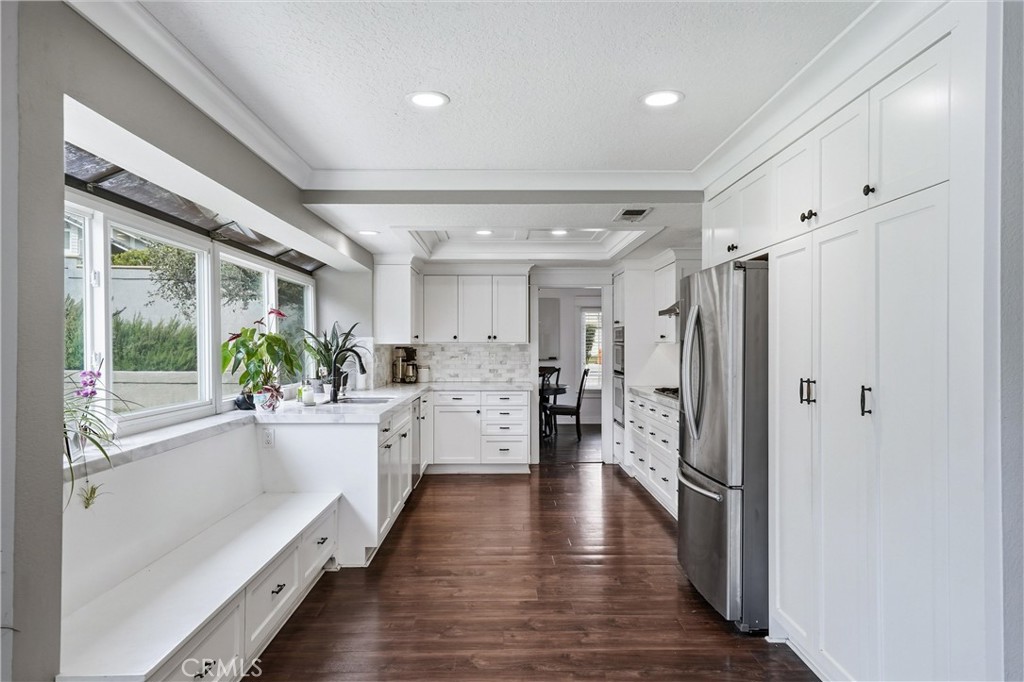 282 North Willow Springs Road Orange, CA 92869 - Photo 16 of 43 a large white kitchen with white cabinets and wooden floor