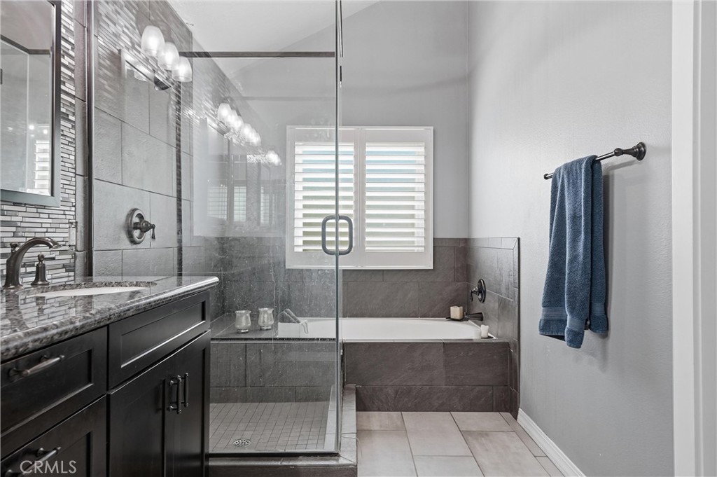 282 North Willow Springs Road Orange, CA 92869 - Photo 26 of 43 a bathroom with a granite countertop sink a mirror and a bathtub