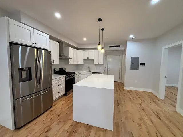 a kitchen with refrigerator a microwave and wooden floor
