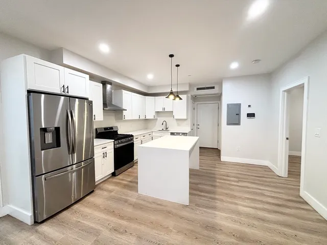 a large kitchen with a refrigerator and a sink