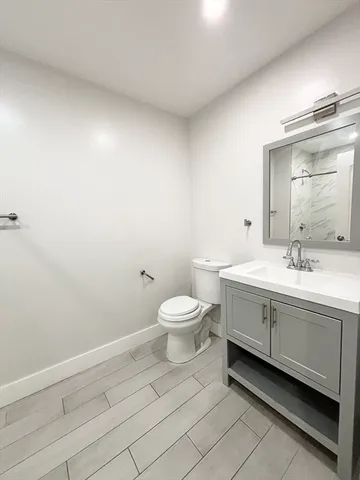 a bathroom with a toilet a sink and mirror