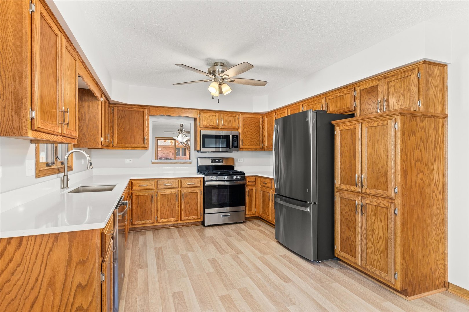 822 Eagle Creek Road Elwood, IL 60421 - Photo 10 of 41 a kitchen with stainless steel appliances granite countertop a refrigerator a sink dishwasher and wooden cabinets with wooden floor