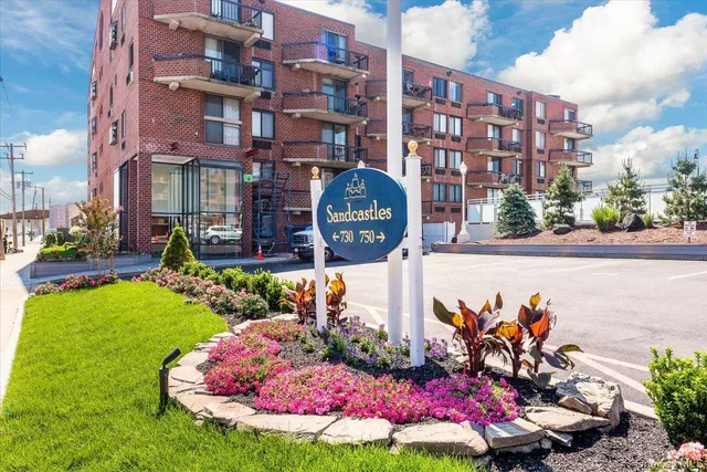 a front view of a multi story residential apartment building with yard