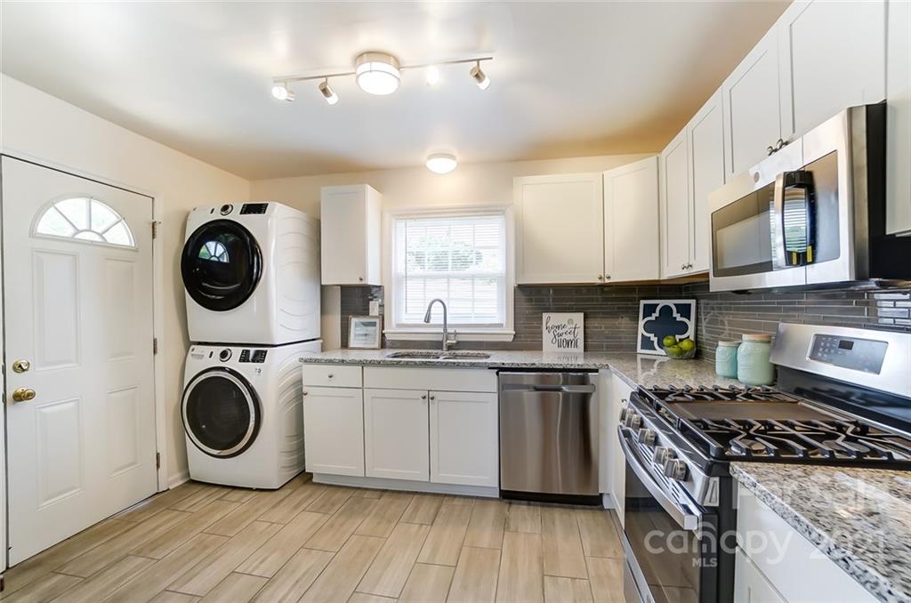 4033 Fieldcrest Road Charlotte, NC 28217 - Photo 5 of 17 a kitchen with stainless steel appliances granite countertop a wooden floors a stove and a microwave