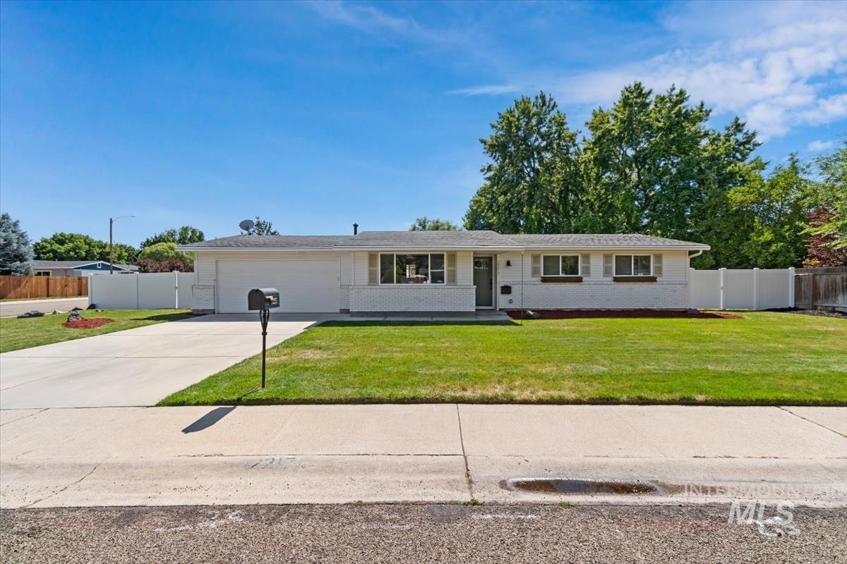 2217 North Middlefield Road Boise, ID 83704 - Photo 1 of 34 Ranch-style residence featuring a white brick and siding exterior, an attached two-car garage, a concrete driveway, a front lawn, and a white vinyl privacy fence