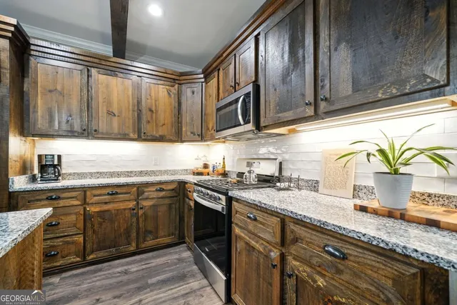 a kitchen with stainless steel appliances granite countertop a sink a stove and cabinets