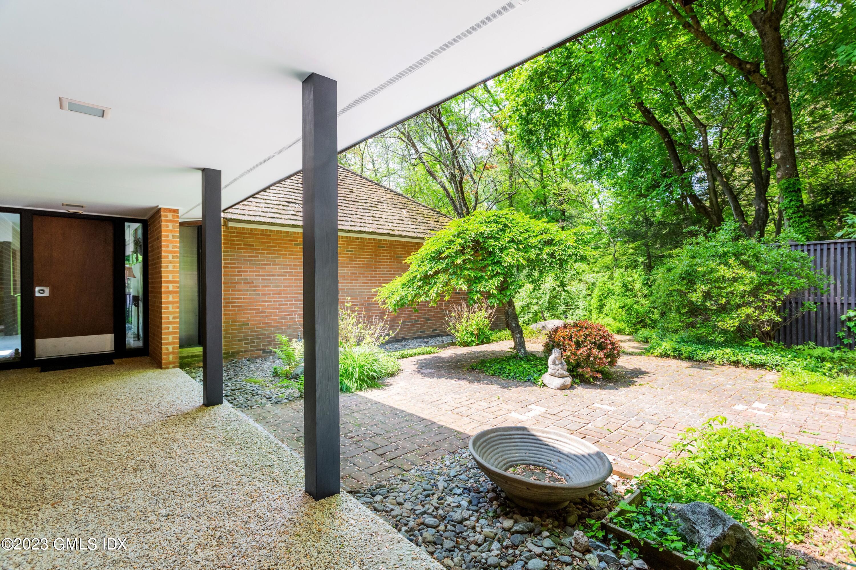 140 Round Hill Road Greenwich, CT 06831 - Photo 4 of 49 a view of a backyard with table and chairs and potted plants
