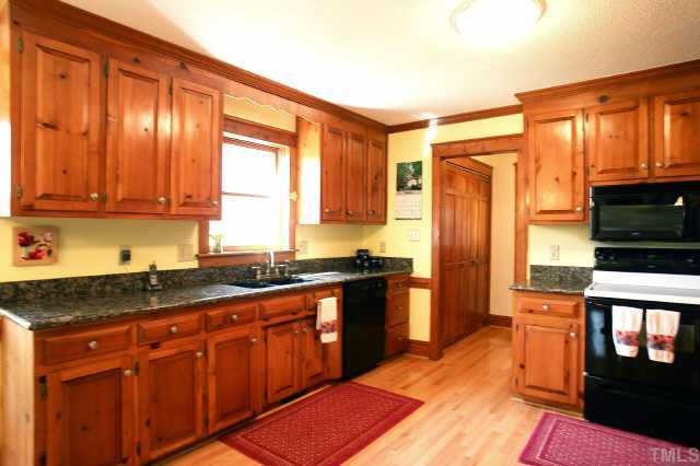 2832 Mattlyn Court Raleigh, NC 27613 - Photo 6 of 12 a kitchen with stainless steel appliances granite countertop a refrigerator a sink dishwasher a stove with wooden cabinets and floor