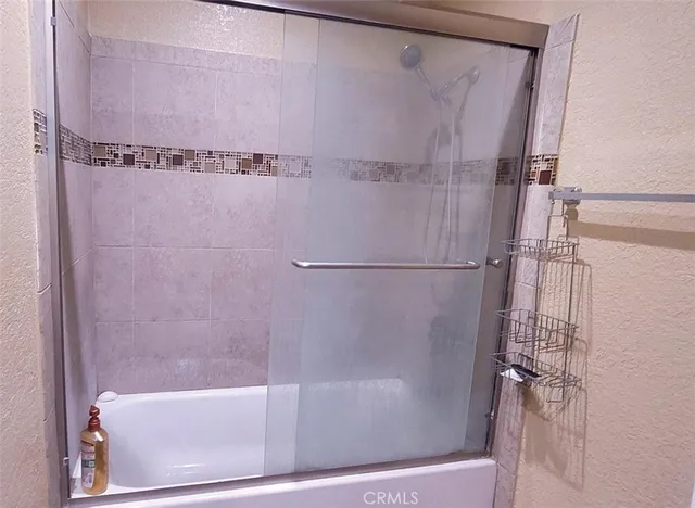 a bathroom with a shower and a glass door