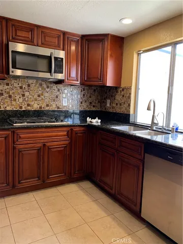 a kitchen with stainless steel appliances granite countertop a stove microwave and sink